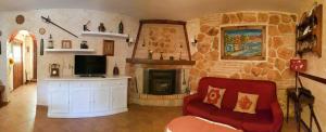 阿拉尔孔Casa Eloísa的客厅设有石制壁炉和红色沙发。