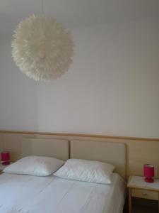 苏佩塔尔ROOMS LUCE 2 & Supetar的一间卧室配有一张带两个白色枕头的床