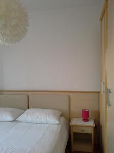苏佩塔尔ROOMS LUCE 2 & Supetar的一间卧室配有一张床和一张红色蜡烛的桌子