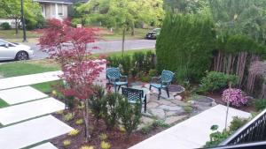 温哥华Vancouver Traveller B&B的阳台的花园,带两把椅子和鲜花