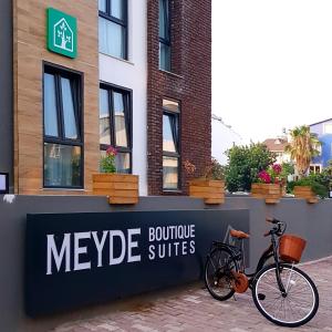 安塔利亚Meyde Boutique Suites的停放在梅吉格高昂套房标志旁的自行车