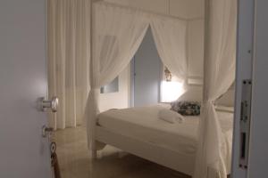 圣维托罗卡波Cocciu d'amuri的白色卧室设有天蓬床和窗户