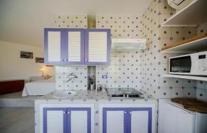 阿纳卡普里La Rotonda的厨房配有紫色橱柜和水槽