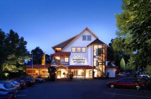 巴特索登-阿伦多夫Romantik Hotel Ahrenberg的停车场内有车辆的旅馆