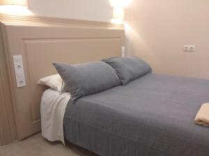 马拉加Apartamentos AS Malaga centro historico的床上有蓝色枕头