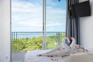 曼努埃尔安东尼奥El Faro Containers Beach Hotel的两只白天鹅躺在窗前的床上