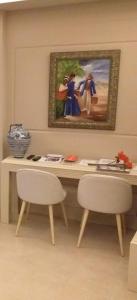 马拉加Apartamentos AS Malaga centro historico的一张桌子、两把椅子和墙上的一幅画