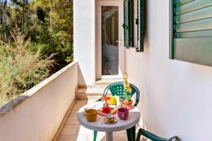 诺沃利Le Dimore di Palma的阳台上的小桌子上放着杯子和杯子