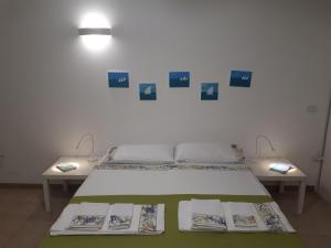 圣卡特琳娜迪纳德Monolocale Santa Caterina的一间卧室配有一张床和两张墙上照片的桌子。