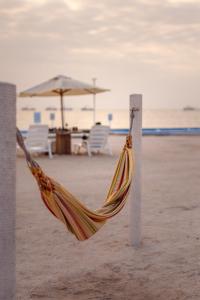 帕拉卡斯Apartamento Frente a Islas Ballestas的海滩上的吊床,配有椅子和遮阳伞