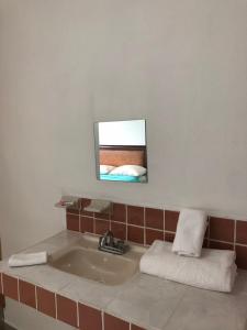 坎昆Airport Sleepy Inn的浴室设有水槽和墙上的镜子