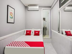 圣保罗OYO Hotel Boneville, São Paulo的白色客房,床上配有红色枕头