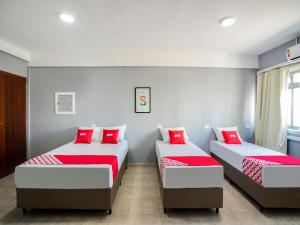 圣保罗OYO Hotel Boneville, São Paulo的宿舍间内的两张床,配有红色枕头
