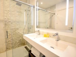 塞维利亚Hotel Legado Alcazar的一间带水槽和淋浴的浴室