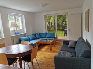 柏林Beautiful House in Zehlendorf的客厅配有蓝色的沙发和桌子