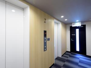 大阪Tabist Hotel Asiato Namba的走廊上设有黑色的门和黑色电梯