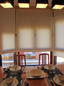 阿尔巴塞特Apartamentos Legazpi的桌子上摆放着椅子和盘子,玻璃杯