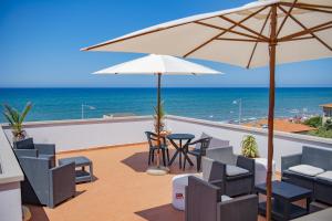 圣温琴佐Hotel del Sole的庭院配有桌椅和遮阳伞。