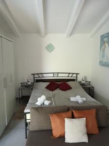 MurineApp Neno的一间卧室配有红色和白色枕头的床