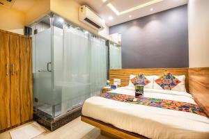 孟买FabExpress Marol Metro Andheri East的一间卧室设有一张床和一个玻璃淋浴间
