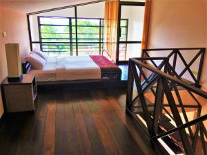 曾蒙海滩楚昌别墅度假酒店的一间卧室设有一张床和一个大窗户