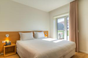 波尔图Spot Family Apartments的卧室设有一张白色大床和一扇窗户。