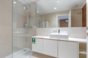 波尔图Spot Family Apartments的白色的浴室设有水槽和淋浴。