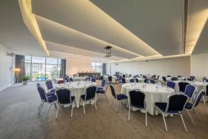 马普托Meliá Maputo Sky的宴会厅配有白色的桌子和蓝色的椅子