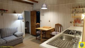 圣贾科莫瑜珈与布布露营酒店的厨房配有水槽、桌子和沙发