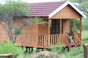 MkuzeIgula lodge的小木屋设有门廊和两把椅子