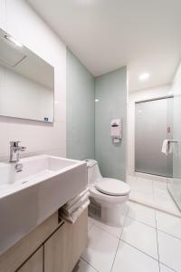 高雄鲔鱼家族饭店盐埕馆的白色的浴室设有水槽和卫生间。