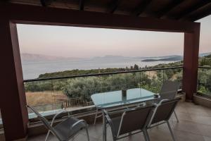 尼基亚娜Ionion Fos的阳台享有玻璃桌和椅子的景色