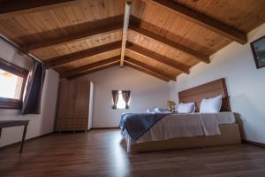 尼基亚娜Ionion Fos的一间卧室设有一张床和木制天花板