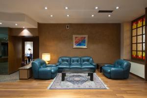 伦德旧金山酒店的客厅配有蓝色皮革家具和桌子