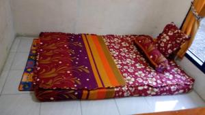 SapitMudung Keramat Homestay的一堆毯子坐在房间里地板上