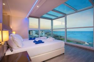 法里拉基Pegasos Deluxe Beach Hotel的一间卧室设有一张大床和大窗户