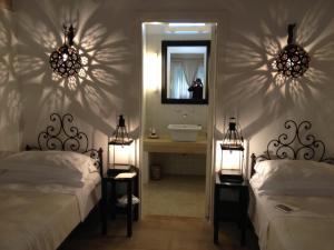奥特朗托马赛利亚蒙特劳洛酒店的一间带两张床的卧室和一间带镜子的浴室