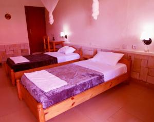 KibuyeRebero Kivu Resort的紫色墙壁客房的两张床