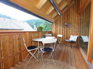 克拉尼斯卡戈拉Apartments Maison的木制甲板上配有桌椅的天井