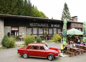 小莫拉夫卡Penzion a restaurace Na Hvězdě的停在餐厅前的老红色汽车