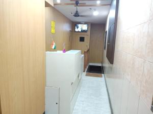 孟买Mabrook Dormitory的走廊上,房间里设有白色冰箱