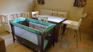 波亚纳布拉索夫Ski & Bike Residence的一间设有桌子和一张带桌椅的婴儿床的房间