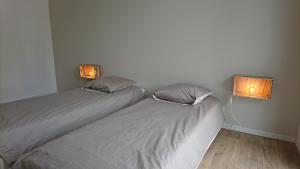 普罗梅尔Villa Gavrinis的两张床位于带两盏挂在墙上的灯的房间