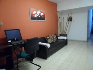 米纳斯米纳斯酒店的客厅配有沙发和笔记本电脑(书桌)