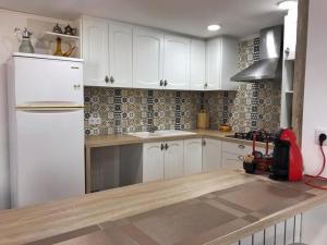 勃朗峰Cal Pere de L'Onclet的厨房配有白色橱柜和白色冰箱。