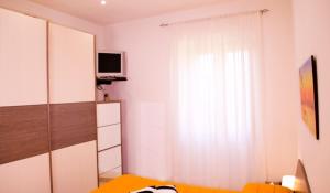 苏特里Butterfly casa vacanze的一间卧室设有一张床和一个带电视的窗户。