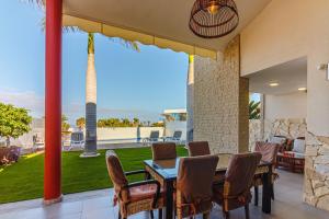阿德耶Villa La Caleta Golf的一个带桌椅的海景庭院