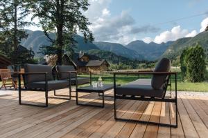 博希尼Hotel Majerca的木制甲板上配有两把椅子和一张桌子的庭院