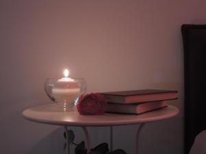 马泰拉Artemide B&B的蜡烛和玫瑰花桌子上的书籍