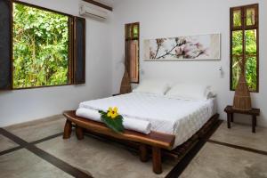 圣米格尔-杜斯米拉格里斯Pousada da Amendoeira的一间卧室配有带毛巾的床和2个窗户。
